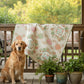 Dog sitting on a wooden deck with a Pastel Floral and chain quilt with cream background draped on a wooden railing. Quilt uses Kindness fabric line by Deb Strain and is designed by Coach House Designs