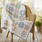Quilt with floral pattern in pastel colors on a white background